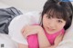A young woman laying on a bed with a pink pillow.