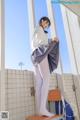 A woman in white tights is standing on a chair.