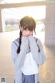 A young woman in a school uniform is posing for a picture.