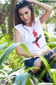 A woman sitting on a rock in the woods.