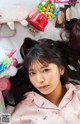 a woman laying on top of a bed next to a stuffed animal