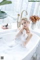 A woman sitting in a bathtub covered in foam.