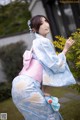 A woman in a blue and pink kimono is posing for a picture.