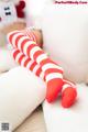 A pair of red and white striped stockings sitting on a white couch.