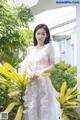 A woman in a white dress posing for a picture.