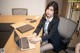 A woman sitting at a desk with a laptop computer.