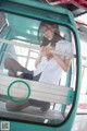 A woman in a white shirt is sitting in a cable car.