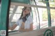 A woman in a white shirt and tie standing on a bus.