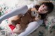 A woman laying on a bed holding a teddy bear.