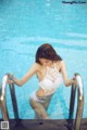 A woman in a white lingerie standing in a swimming pool.