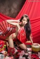 A woman in a red lingerie sitting on a table with money.