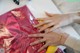 A woman's hands on a red bag with a banana.