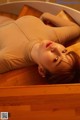 A woman laying on top of a wooden table.